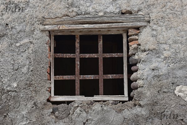 Vergittertes Fenster an einem verfallenen Haus