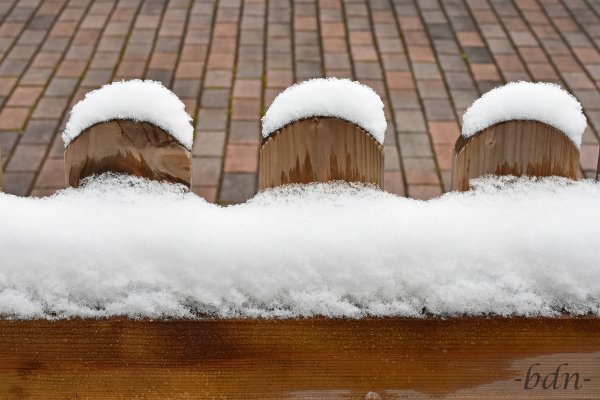 Holzzaun mit Schneehäubchen