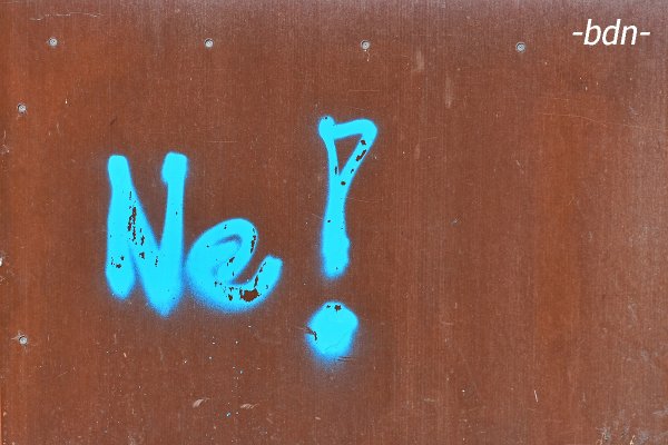 Statement Ne! auf einer rostigen Wand